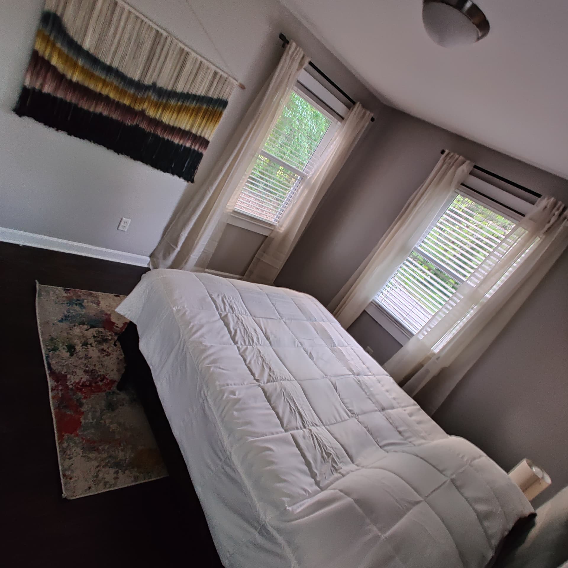 Gresham Park Getaway — bedroom with woven wall hanging and area rug