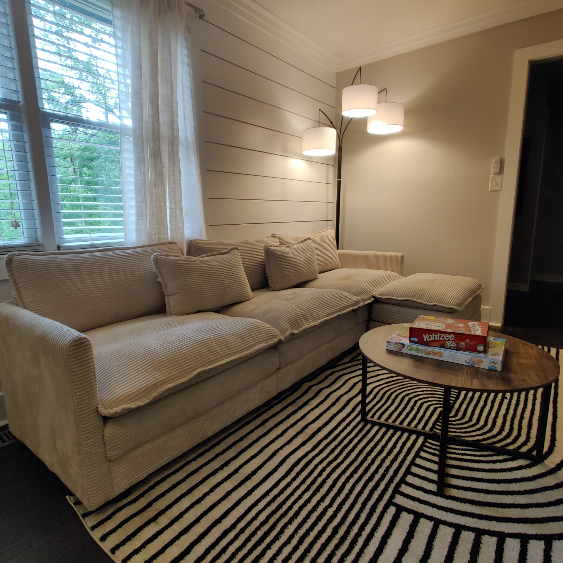 Gresham Park Getaway — living room sectional with games and floor lamp