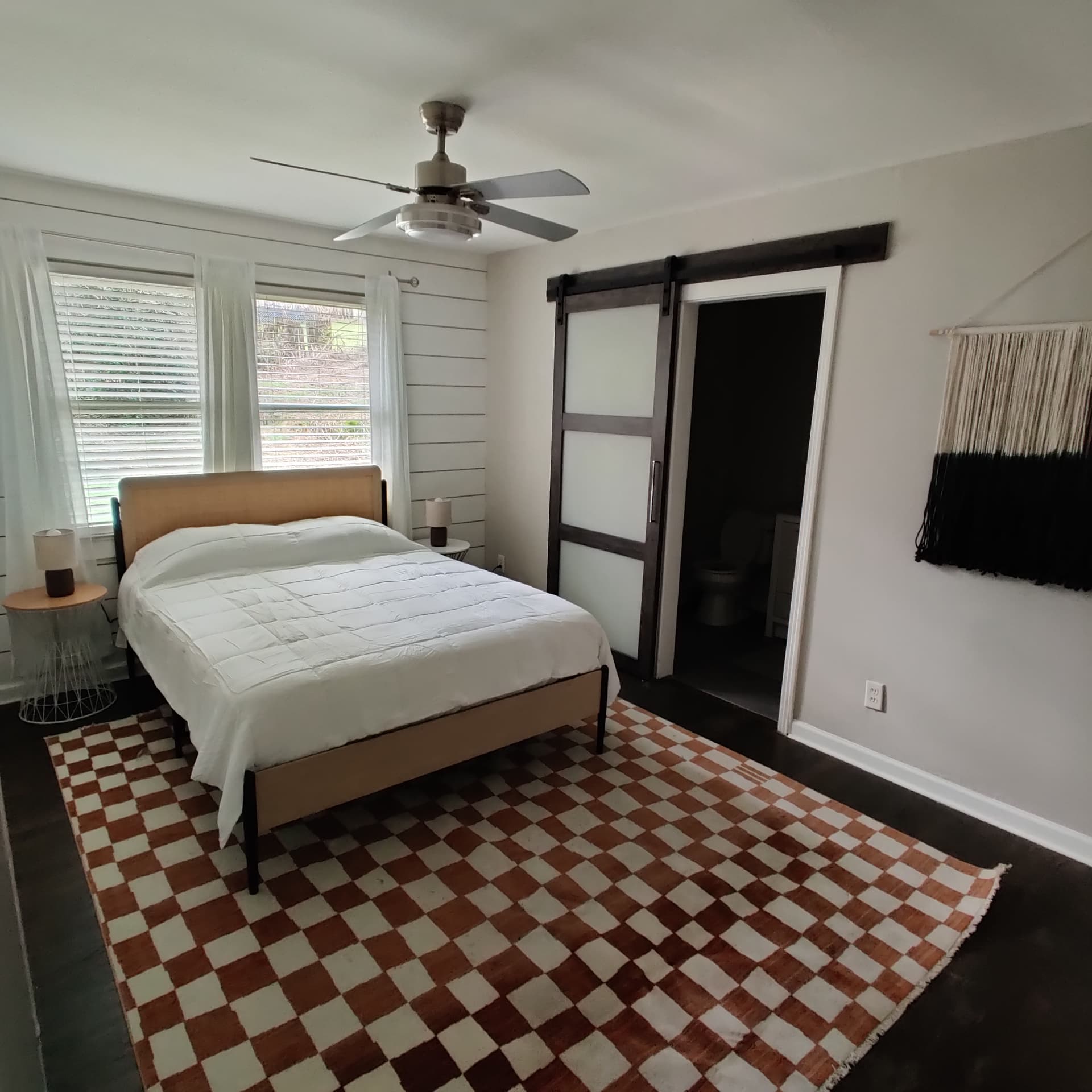 Gresham Park Getaway — bedroom with checkered rug and sliding barn door
