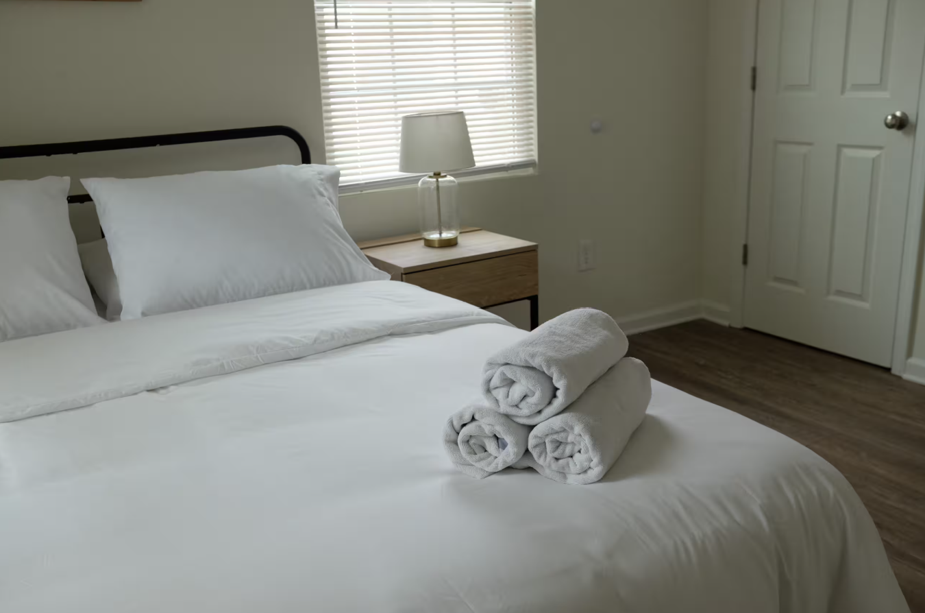 Beltline Bungalow — bedroom with crisp white linens and rolled towels