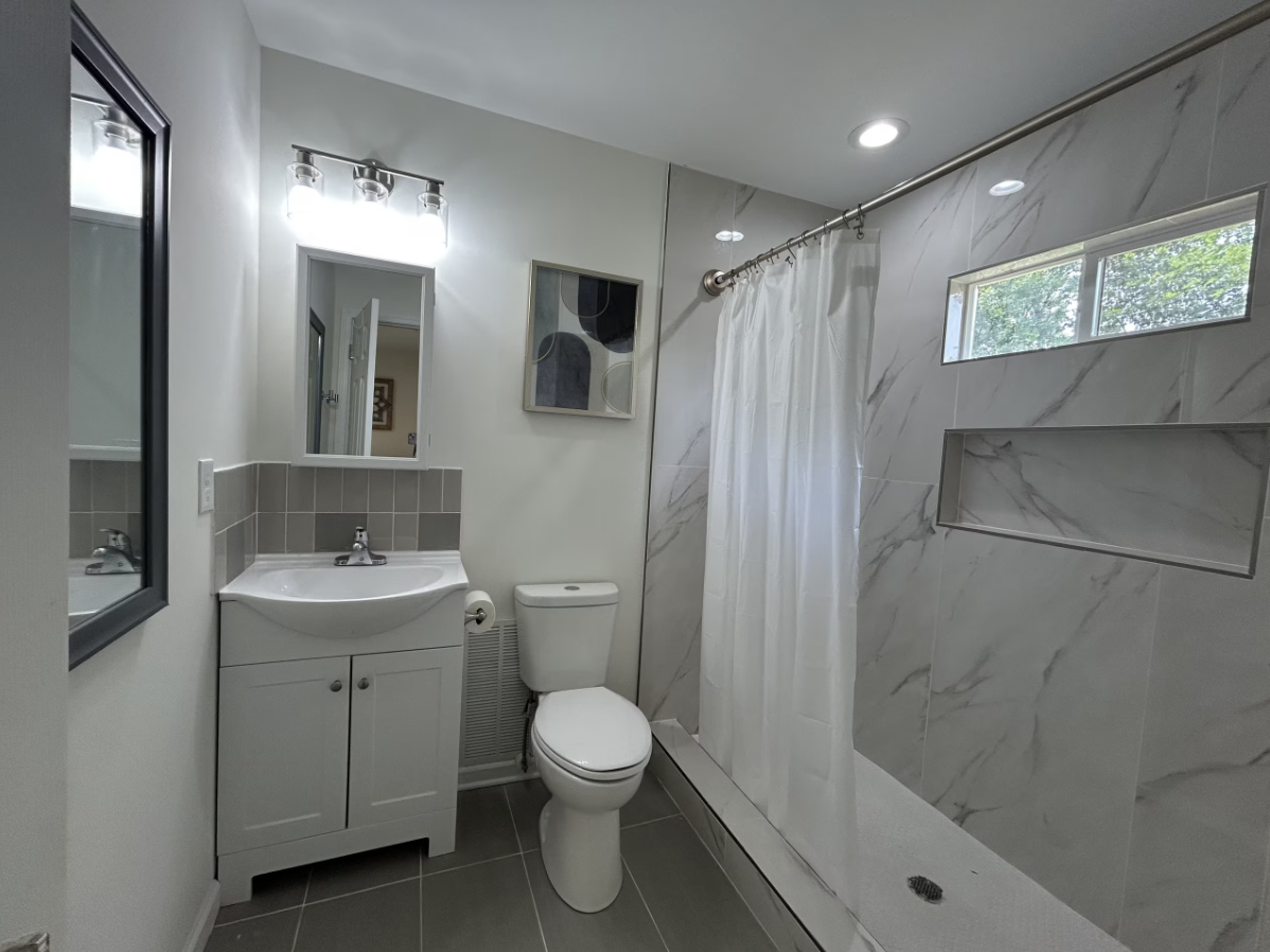 Beltline Bungalow — bathroom with marble-tile shower and vanity